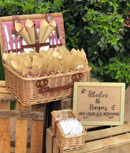 cesto de mimbre con cucuruchos con confeti natural y pompas para tirar a los novios